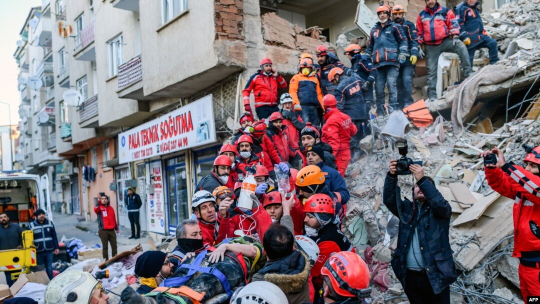 Abakozi b'inzego z'ubutabazi barokora umugore wagwiriwe n'inyubako ahitwa Elazig, mu burasirazuba bwa Turukiya