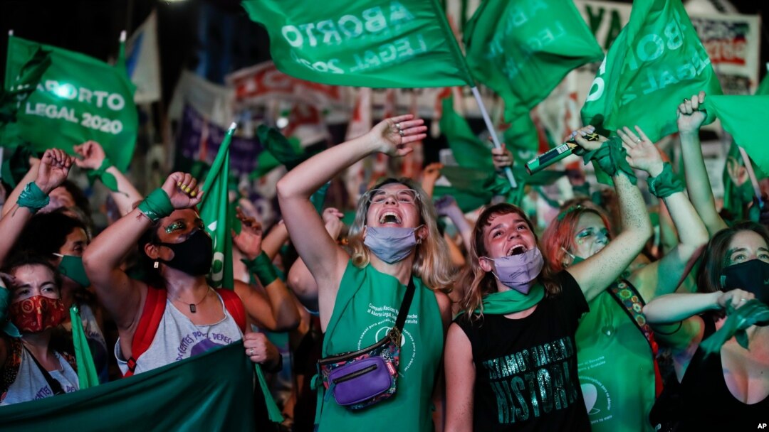 Aktivis hak-hak aborsi menonton streaming video langsung dari anggota parlemen dalam sesi, di luar Kongres di Buenos Aires, Argentina, Rabu, 30 Desember 2020. Kongres menyetujui undang-undang yang melegalkan aborsi di Argentina. (Foto: AP/Natacha Pisarenko)