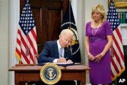 조 바이든(왼쪽) 미국 대통령이 25일 부인 질 바이든 여사가 지켜보는 가운데 총기 규제 강화법안에 서명하고 있다.