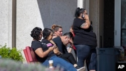 Kerabat korban penembakan massal di toko Walmart di El Paso, negara bagian Texas, menunggu informasi dari otoritas di pusat reunifikasi di El Paso, Minggu, 4 Agustus 2019. (Foto: AP)