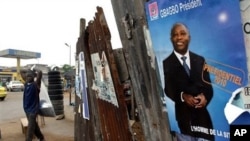 A man walks past an election poster for incumbent President Laurent Gbagbo, as presidential campaigning kicked off, 15 Oct. 2010 in Abidjan, Ivory Coast