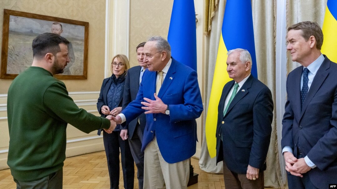Fotografía distribuida por la Embajada de EEUU en Ucrania el 23 de febrero de 2024, muestra al presidente de Ucrania, Volodymyr Zelenskyy (izquierda), saludando al líder de la mayoría del Senado de los Estados Unidos, Chuck Schumer (centro), y a su delegación.
