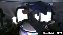 Jeff Bezos di dalam penerbangan Blue Origin, berusaha menangkap popcorn dengan mulutnya. (AFP PHOTO / Blue Origin)