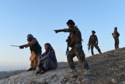 This photograph taken on July 14, 2021 shows Salima Mazari, 2nd L, a female district governor in male-dominated Afghanistan, looking on while accompanied by security personnel near the frontlines against the Taliban in Balkh province.