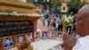 FILE - A man prays in front of portraits of victims of a fatal 1997 grenade attack on an opposition rally, which are displayed during a ceremony to remember the victims, at a monument in Phnom Penh, Cambodia, March 30, 2018. (Reuters)