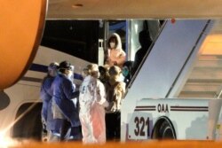 American evacuees from the coronavirus outbreak in China board a bus after arriving by flight to Eppley Airfield in Omaha, Nebraska, Feb. 7, 2020.