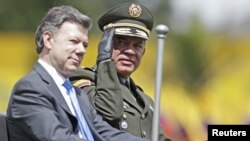 El director de la policía colombiana, José Roberto León, saluda desde un auto militar, mientras acompaña al presidente Juan Manuel Santos.