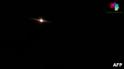 This image grab taken from a handout video released by the Syrian General Organization of Radio and Television late on Aug. 24, 2019 shows lights in the sky reportedly over Aqraba, southeast of the Syrian capital Damascus during an Israeli airstrike.