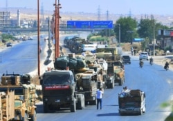 FILE - A Turkey Armed Forces convoy is seen at a highway between Maaret al-Numan and Khan Sheikhoun in Idlib province, Syria, Aug. 19, 2019.