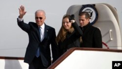 Wakil Presiden Joe Biden melambaikan tangannya saat keluar dari pesawat Air Force Two dengan cucunya Finnegan Biden dan putranya Hunter Biden di bandar udara Beijing, China (4/12). (AP/Ng Han Guan)