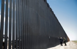 U.S. President Donald Trump points at the wall as he talks with U.S. Border Patrol Chief Rodney Scott while touring a section of recently constructed U.S.-Mexico border wall in San Luis, Arizona, June 23, 2020.