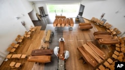 Coffins arriving from the Bergamo area, where the coronavirus infections caused many victims, are being unloaded from a military truck that transported them in the cemetery of Cinisello Balsamo, near Milan in Northern Italy, March 27, 2020. 