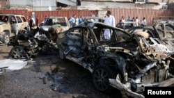 Iraqis inspect the site of a car bomb attack in Basra, southeast of Baghdad, Sept. 30, 2014.