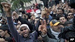 Tunisian protesters shout slogans in front of the RCD party office after the sign bearing its name was dismantled, in Tunis, 20 Jan 2011