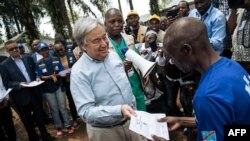 FILE - United Nations Secretary-General Antonio Guterres, left, hands a diploma to an Ebola survivor during a visit to an Ebola treatment center in Mangina, North Kivu province, Sept. 1, 2019.