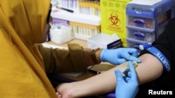 A staff member takes a blood sample during a free medical check-up for the public at the government-run healthcare center in Jakarta, Indonesia, Feb. 10, 2025.