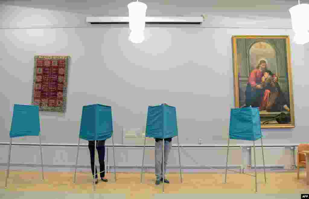 People vote at a polling station during the Swedish general elections in Stockholm.