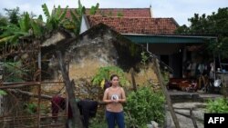 A Vietnamese woman stands outside her house in Yen Thanh district of Vietnam's Nghe An province, Oct. 27, 2019.