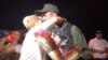 Luz Adriana Chalarca hugs a Venezuelan border guard after giving him a baby Jesus figure as a sign of peace. She organized a prayer vigil on a bridge linking Cúcuta, Colombia, and northwest Venezuela, July 30, 2017. (C. Mendoza/VOA Spanish Service)