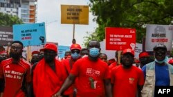 Des membres du parti d'opposition National Democratic Congress (NDC) se tiennent la main lors d'une manifestation antigouvernementale dans les rues d'Accra, au Ghana, le 6 juillet 2021.