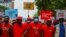 Des membres du parti d'opposition National Democratic Congress (NDC) se tiennent la main lors d'une manifestation antigouvernementale dans les rues d'Accra, au Ghana, le 6 juillet 2021.
