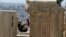FILE - Tourists take photographs atop of the ancient Acropolis hill in Athens, May 9, 2016. Greece expects to welcome a record 27 million tourists this year.