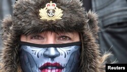 A woman wearing a protective face mask joins former British armed forces members and supporters at a &quot;Respect Our Veterans&quot; parade and rally in London, May 8, 2021.