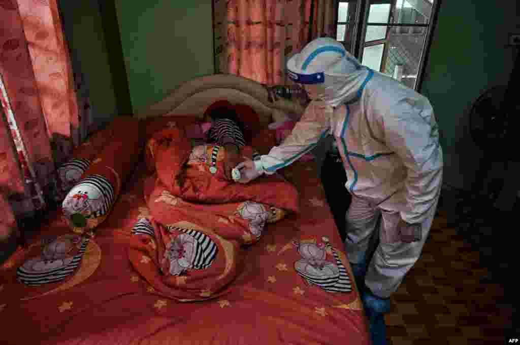 A volunteer from the Zendai organization checks the blood oxygen levels of a woman in home isolation in a COVID-19 affected community of Nong Chok district in the outskirts of Bangkok, Thailand.