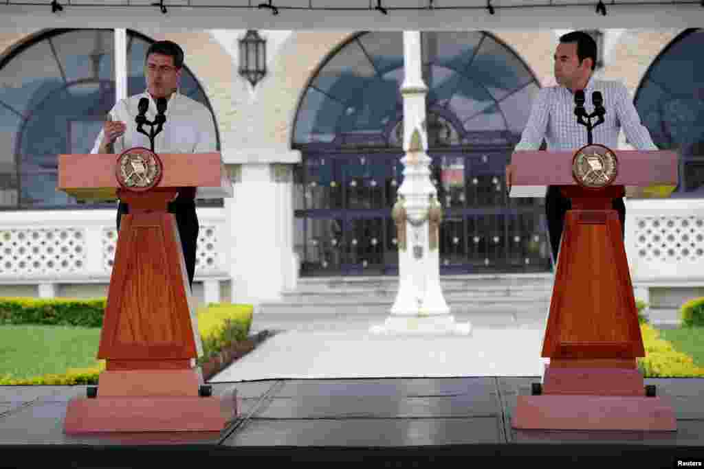 Honduras&#39; President Juan Orlando Hernandez speaks next to his counterpart, Guatemala&#39;s President Jimmy Morales, during a news conference in Guatemala City, Guatemala, Oct. 20, 2018. to talk about the situation of the large caravan of Central American migrants who are trying to reach the United State.
