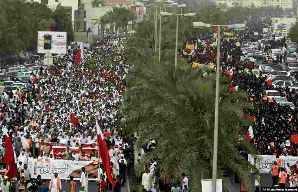 Miles de manifestantes anti gobierno protestan en una avenida a las afueras de Manama, Bahr&eacute;in, con banderas del pa&iacute;s mientras cantan mensajes contra el r&eacute;gimen, durante el primer d&iacute;a de pr&aacute;cticas del F&oacute;rmula Uno 
