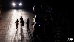 Joggers exercise on a dark street in San Juan, Puerto Rico, after a major power outage hit the island on Dec. 31, 2024.