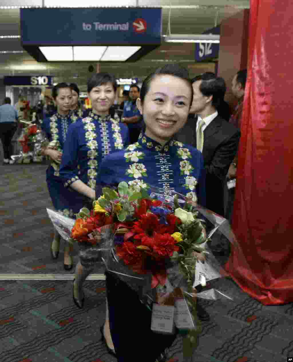 2008年6月9日，海南航空公司的空姐手捧鲜花走在西雅图-塔科马国际机场。海航集团的官网表示：&ldquo;截至2016年12月，海航集团拥有飞机逾1250架，旗下航空运输企业开通国内外航线近1100条，通航城市270余个，年旅客运输量逾9200万人次。运营管理海南航空、天津航空、首都航空、金鹿公务、祥鹏航空、西部航空、福州航空、乌鲁木齐航空、北部湾航空、扬子江航空、桂林航空、长安航空、加纳AWA航空、法国蓝鹰航空等航空公司。&rdquo;