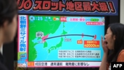 Pejalan kaki melihat ke layar televisi yang melaporkan berita uji coba peluncuran misil Korea Utara, yang diluncurkan melewati Jepang, 15 September 2017.