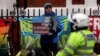 A supporter of WikiLeaks founder Julian Assange holds a placard in front of a police officer, as he stands outside Ecuador's embassy in London, April 6, 2019. 