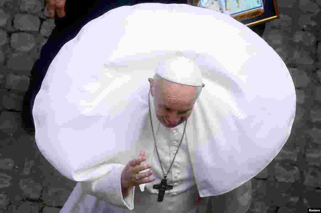 Pope Francis waves before leaving after the weekly general audience, in San Damaso courtyard, at the Vatican.