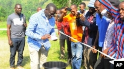 Le leader de l'opposition ougandaise Kizza Besigye nettoie ses mains après avoir voté à son bureau de vote près de sa maison de campagne dans Rukungiri environ 700 kilomètres à l'ouest de Kampala, Ouganda, 18 février 2016. 