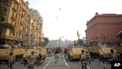 FILE - Egyptian military helicopters fly overhead as army soldiers stand guard at an entrance to Tahrir Square, in Cairo, Egypt, Oct. 6, 2013. The United States on July 26, 2018, released $195 million in military aid to Egypt that had been withheld because of concerns about the country's human rights record.