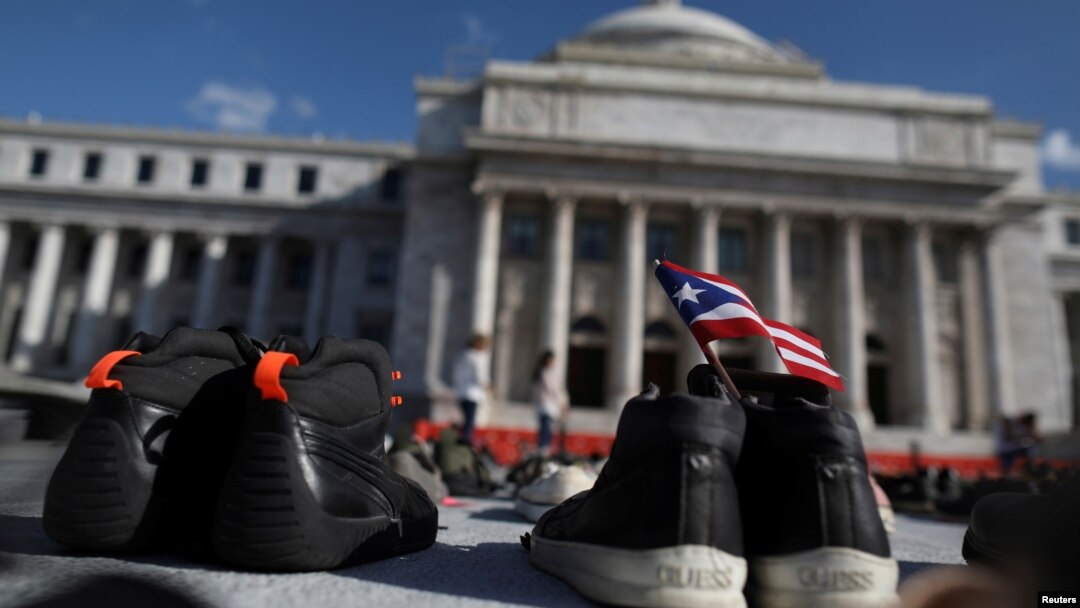 FILE - A Puerto Rican flag is seen on a pair of shoes as hundreds of pairs of shoes are displayed at the Capitol to pay tribute to Hurricane Maria's victims, in San Juan, Puerto Rico June 1, 2018.