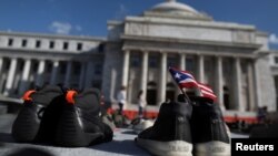FILE - A Puerto Rican flag is seen on a pair of shoes as hundreds of pairs of shoes are displayed at the Capitol to pay tribute to Hurricane Maria's victims, in San Juan, Puerto Rico June 1, 2018.