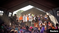 Presiden Indonesia Joko Widodo (C) berbicara kepada korban gempa di dalam tenda darurat di desa Madayin di Lombok Timur, Indonesia, 30 Juli 2018.(Antara Foto/Ahmad Subaidi/via Reuters) 