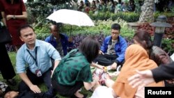 Korban luka dirawat di luar gedung Bursa Efek Indonesia setelah lantai di gedung itu ambruk, 15 Januari 2018. (REUTERS/Darren Whiteside)