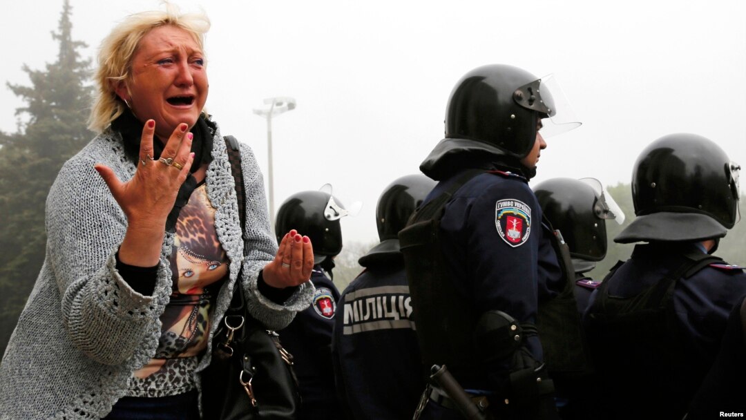 Seorang perempua berduka di depan gedung serikat dagang tempat kebakaran maut terjadi di Odessa, Ukraina (3/5). (Reuters/Yevgeny Volokin)