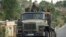 FILE - Ethiopian government soldiers ride in the back of a truck in the Tigray region of northern Ethiopia, May 11, 2021. 