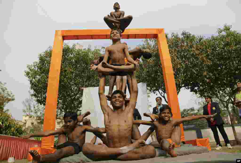 Indian boys perform Mallakhamba, a traditional Indian gymnastic sport on a vertical wooden pole, at a school in Ahmadabad.