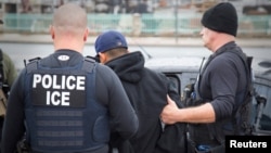 FILEL - U.S. Immigration and Customs Enforcement officers detain a suspect as they conduct a targeted enforcement operation in Los Angeles, Feb. 7, 2017. ICE says, Sept. 27, 2018, it has arrested 150 immigrants across Southern California this week in an operation targeting public safety threats.