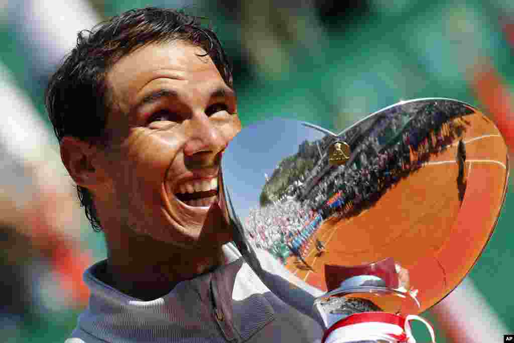 Spain&#39;s Rafael Nadal holds the trophy as he celebrates winning the men&#39;s singles final match of the Monte Carlo Tennis Masters tournament against Japan&#39;s Kei Nishikori in two sets, 6-3, 6-2, in Monaco.