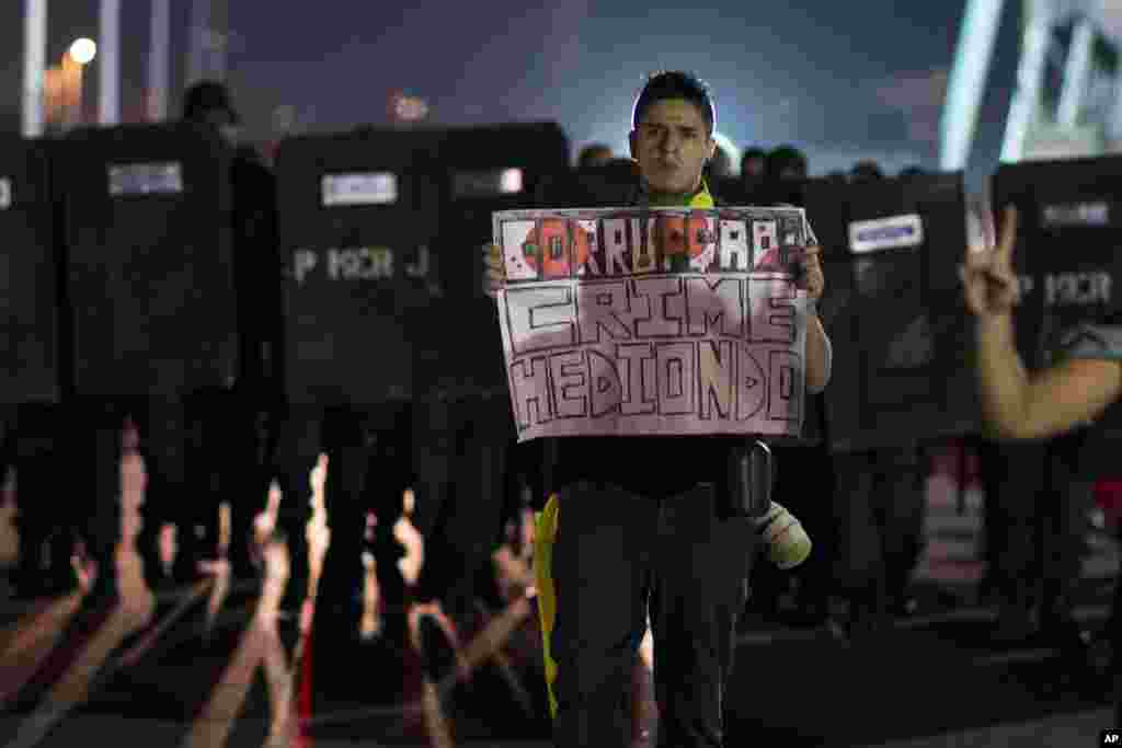 A man holds a sign that reads in Portuguese: "Corruption: Heinous crime," at an anti-government protest in Rio de Janeiro, Brazil, June 21, 2013. 