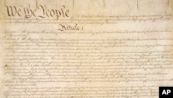 This photo made available by the US National Archives shows a portion of the first page of the United States Constitution.
