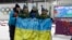 Ukraine's relay team, from left: Vita Semerenko, Juliya Dzhyma, Olena Pidhrushna and Valj Semerenko, with Ukrainian flag with writings on it after winning the gold in the women's biathlon 4x6k relay at the 2014 Winter Olympics, Feb. 21, 2014, in Krasnaya Polyana.