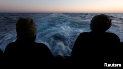 FILE - Rescued migrants look out to sea on the Geo Barents rescue ship, operated by Medecins Sans Frontieres (Doctors Without Borders), as the ship makes its way to the Italian port of Bari, in the central Mediterranean Sea, March 25, 2023.